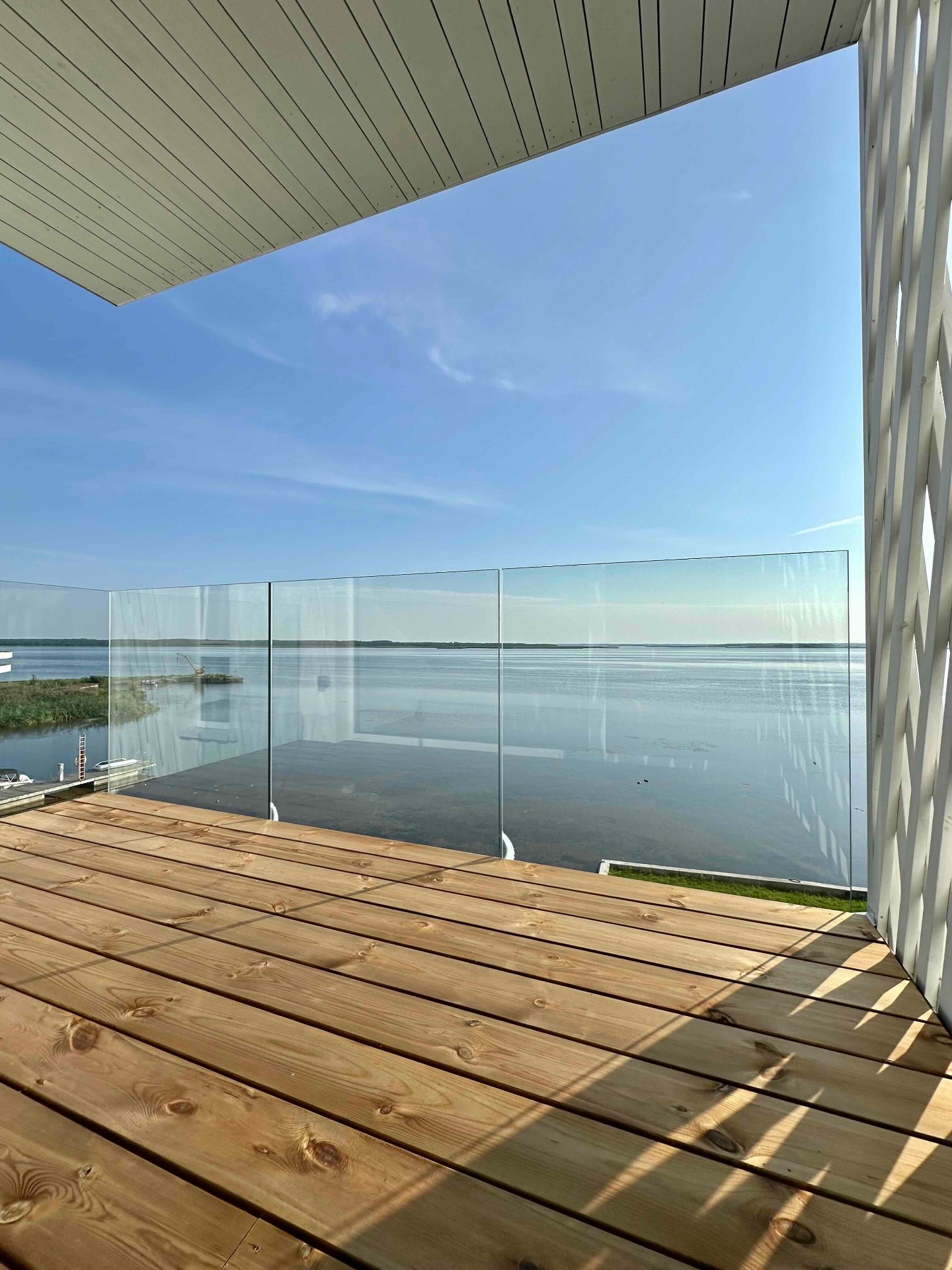 The 5m² east balcony off the bedroom, glass rail straight over the water