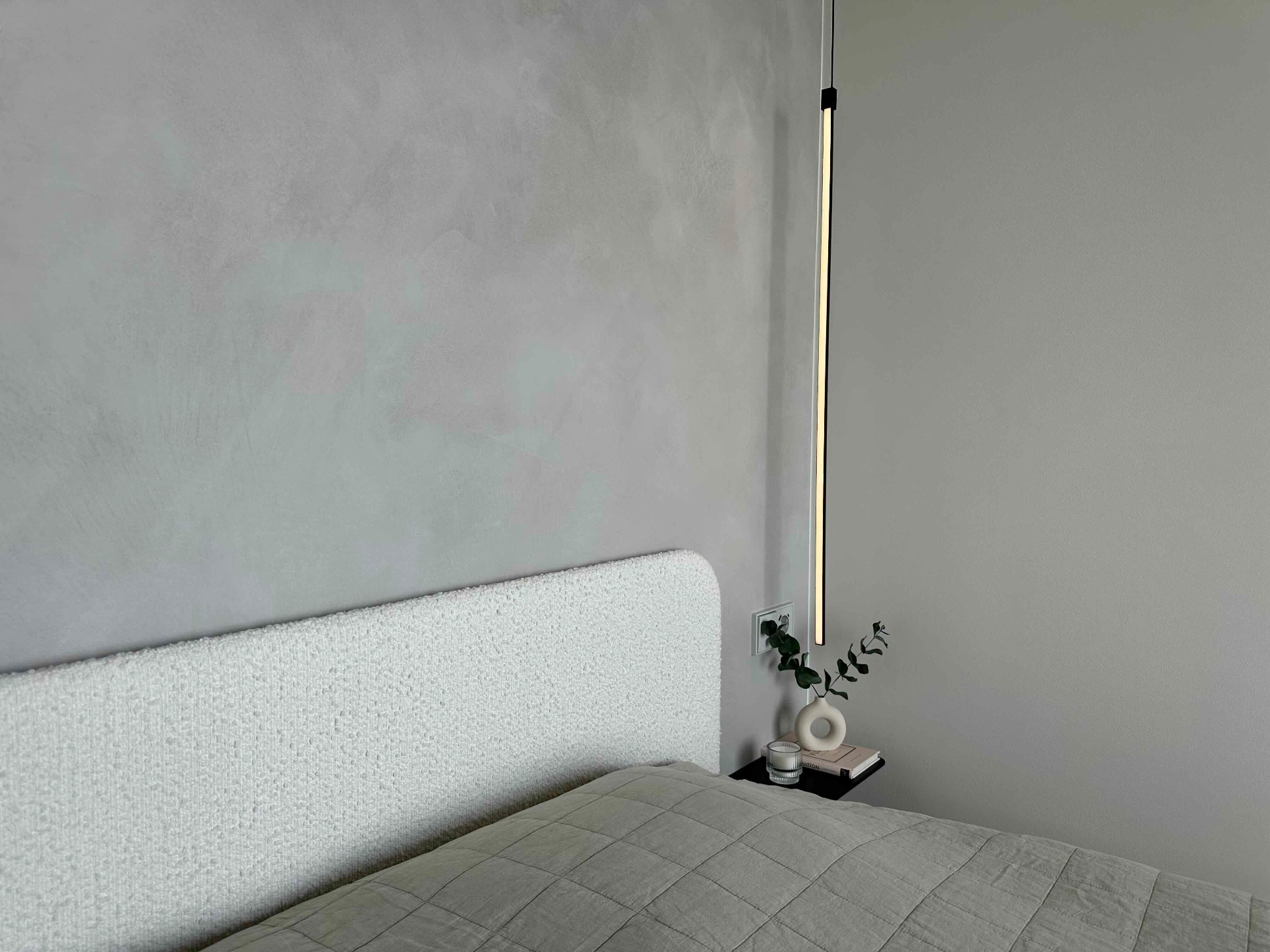 The upholstered headboard and bedside shelf in the bedroom