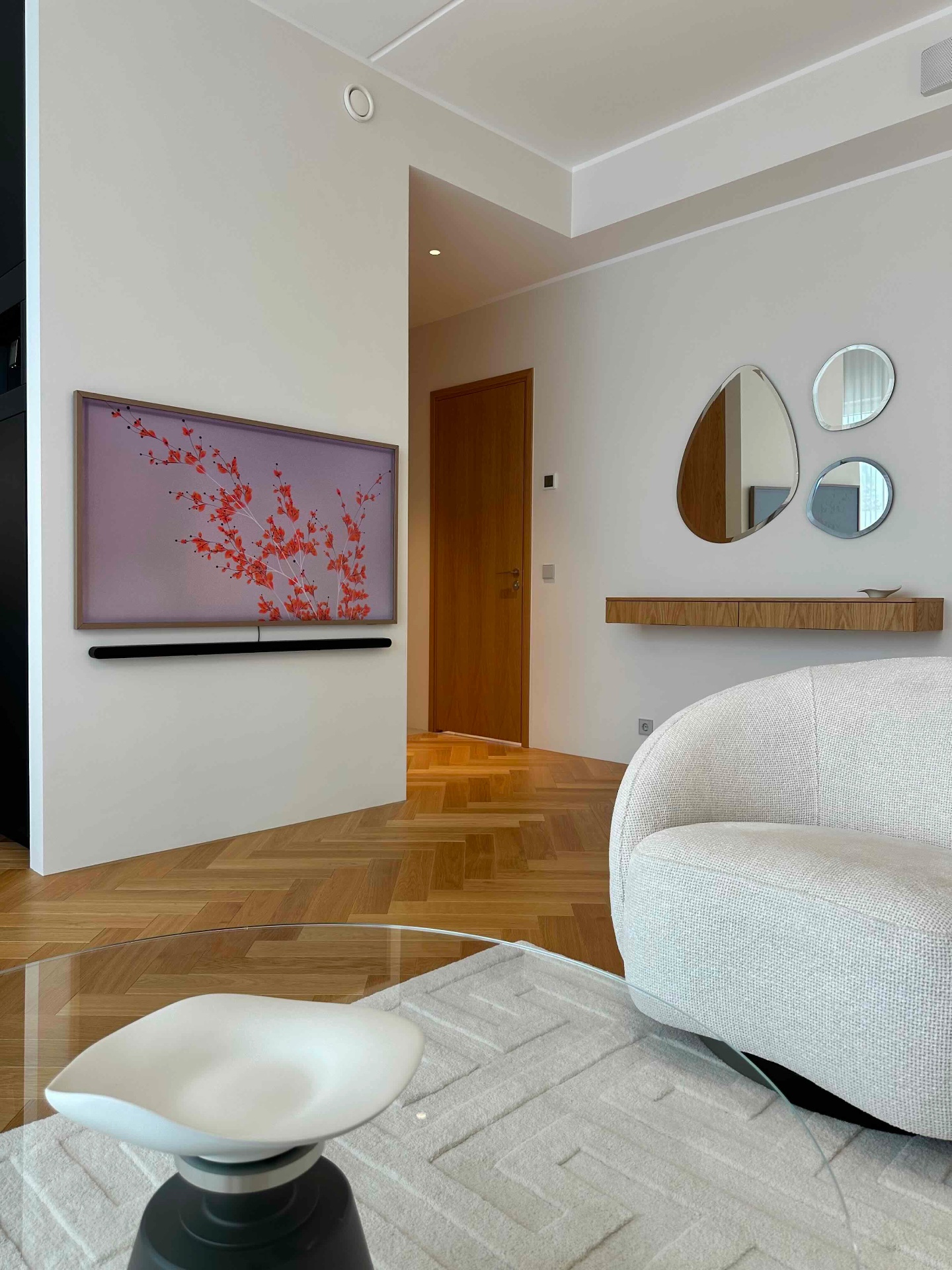 The entrance hall with artwork, mirrors and a shelf