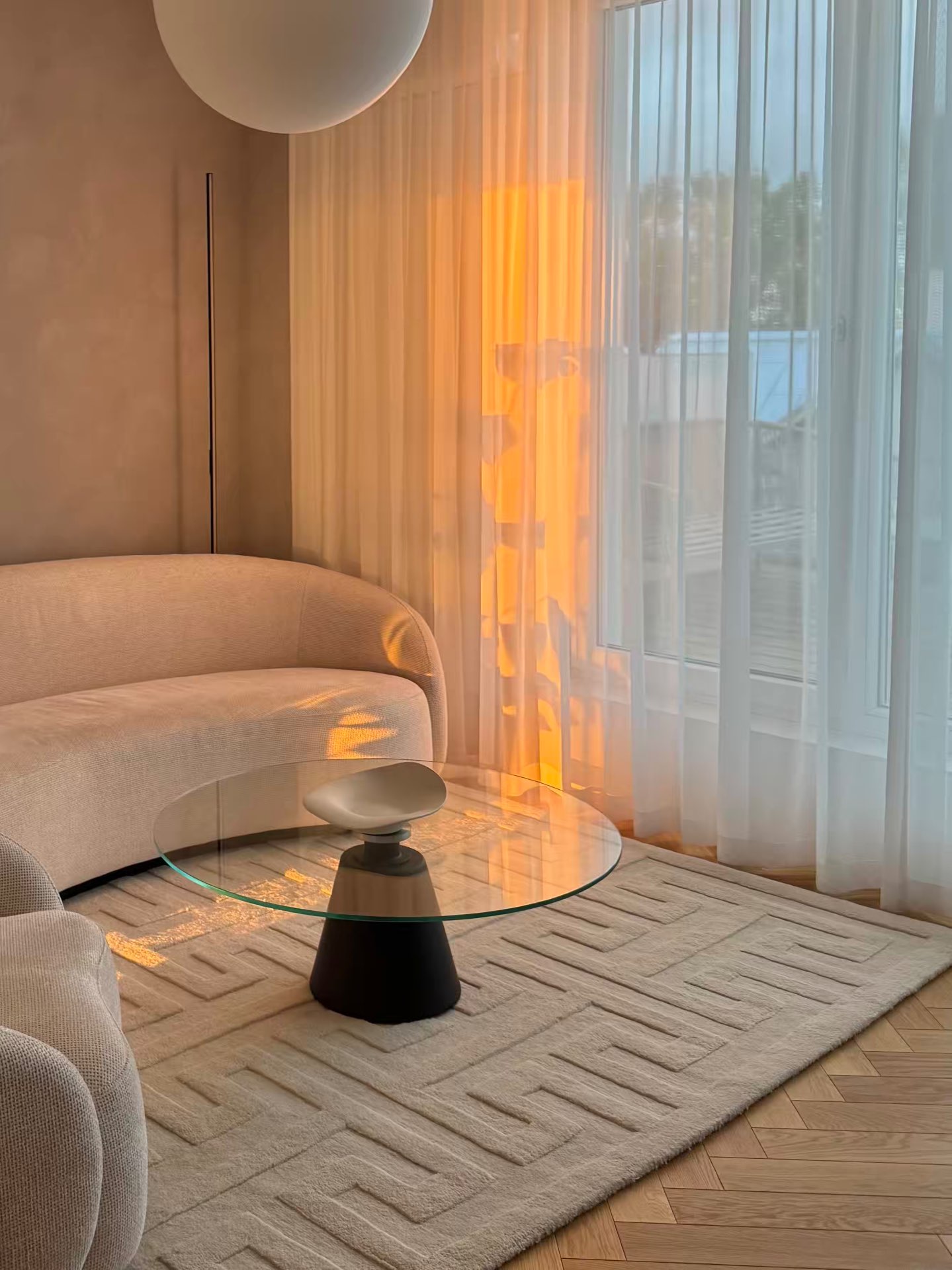 The living room in warm low sunlight through the curtains