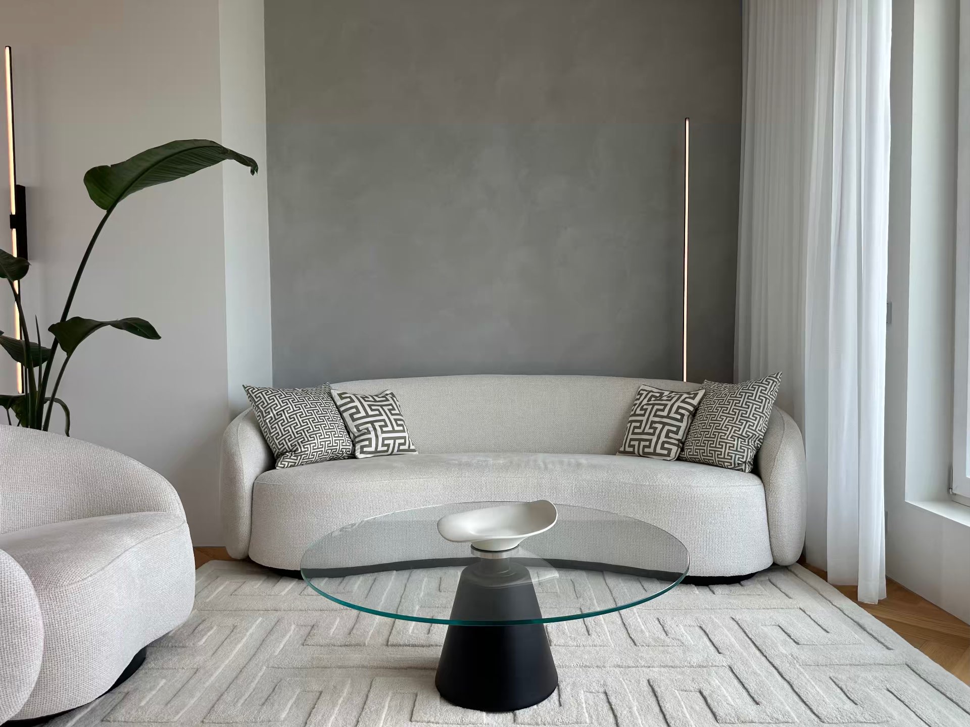 The living room with sofa, armchair and glass table
