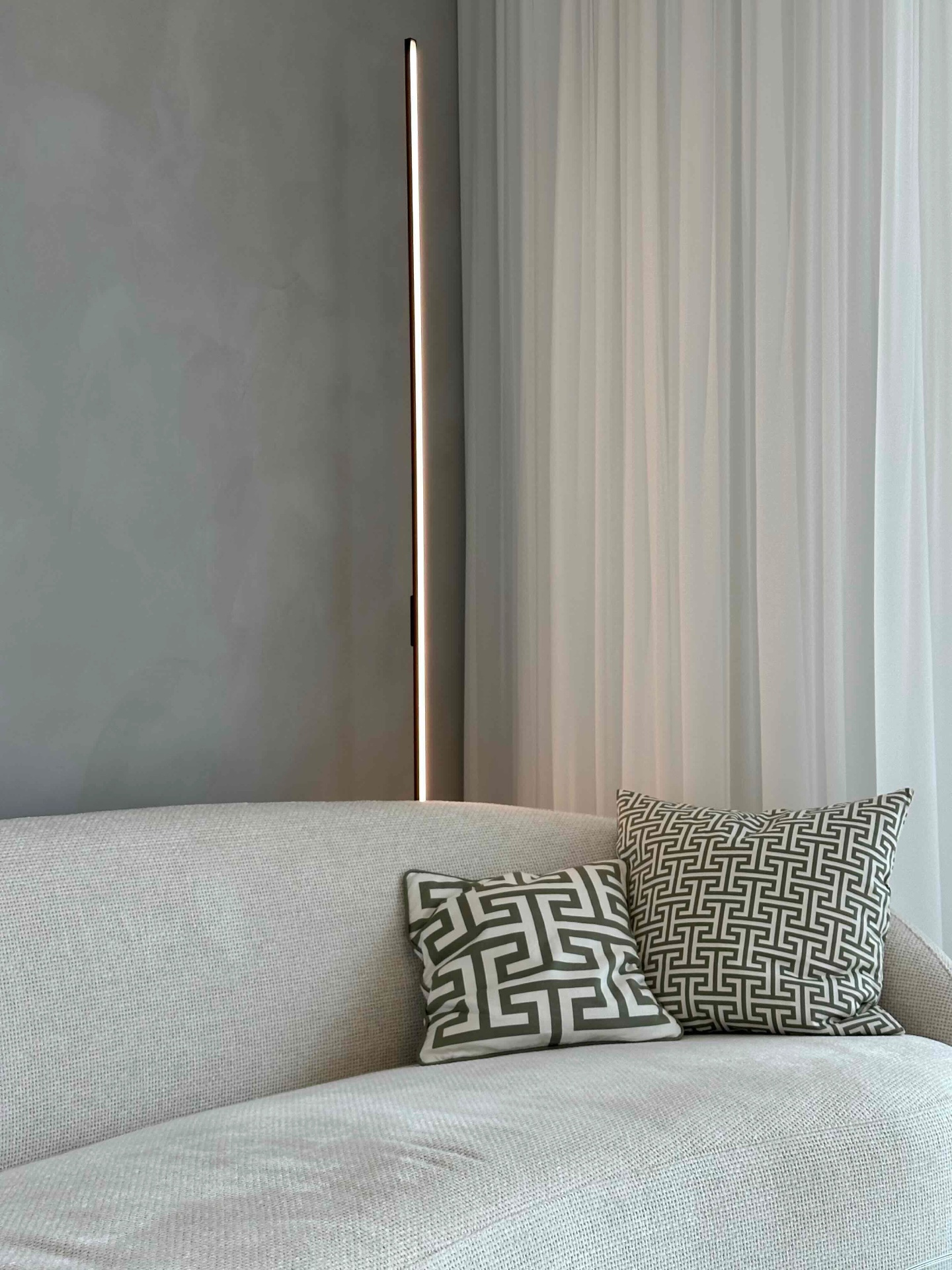 A corner of the living room sofa with patterned cushions