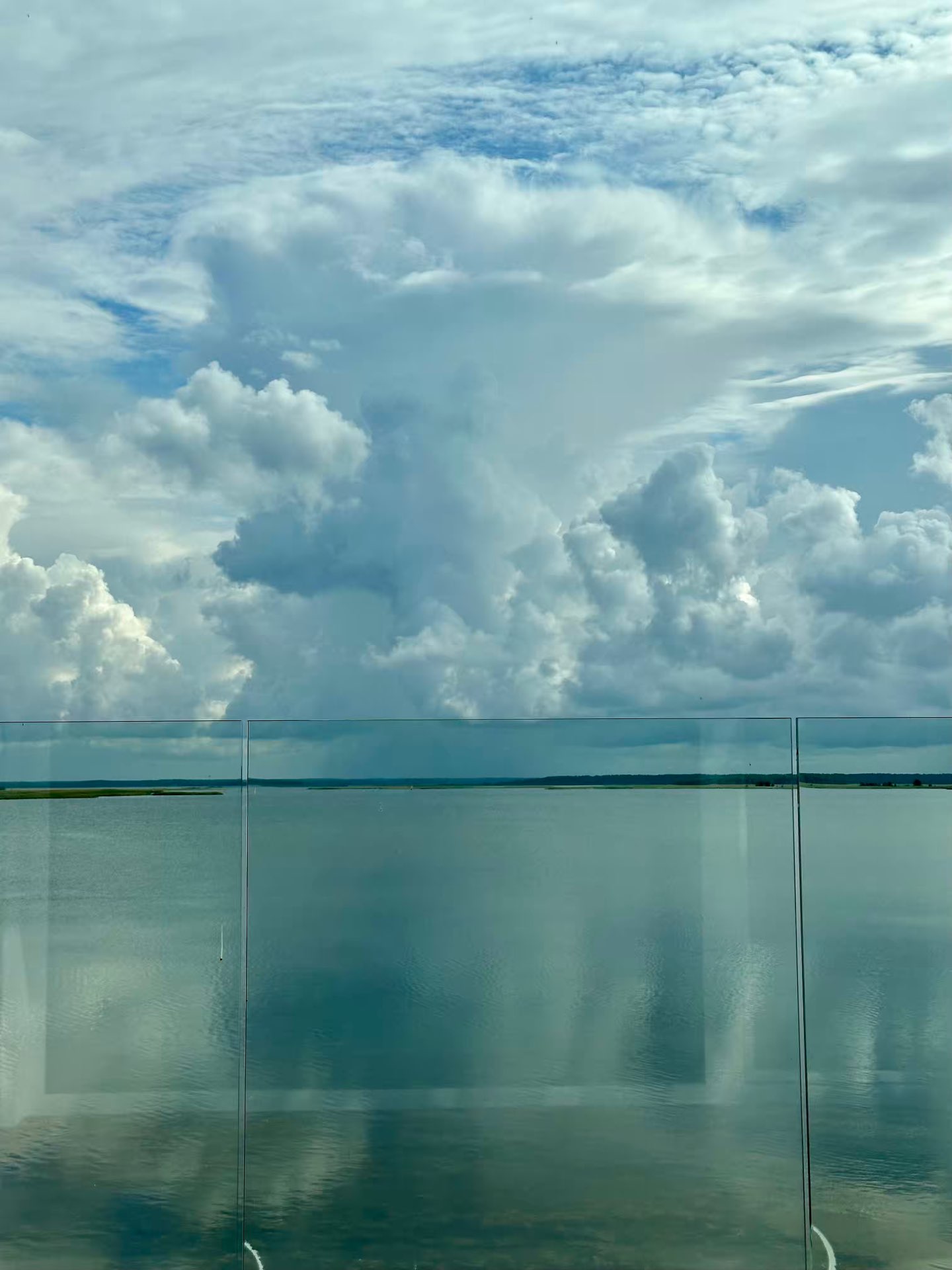 The sea and clouds seen through the glass balustrade